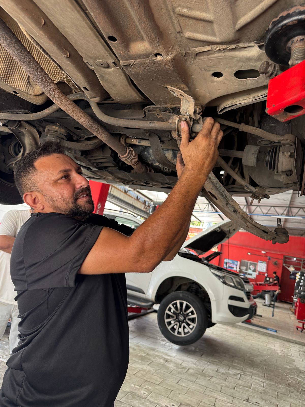 Técnico verificando a parte inferior do veículo